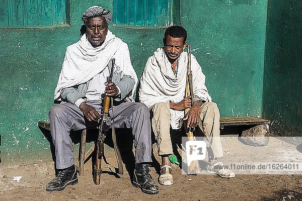 Zwei Wachposten mit Gewehr sitzen auf einer Bank, Simien Mountains Nationalpark, Äthiopien, Afrika