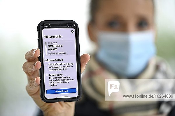 Negatives Testergebnis  Frau mit Mundschutzmaske  zeigt Smartphone mit Corona Warn-APP  Corona-Krise  Stuttgart  Baden-Württemberg  Deutschland  Europa