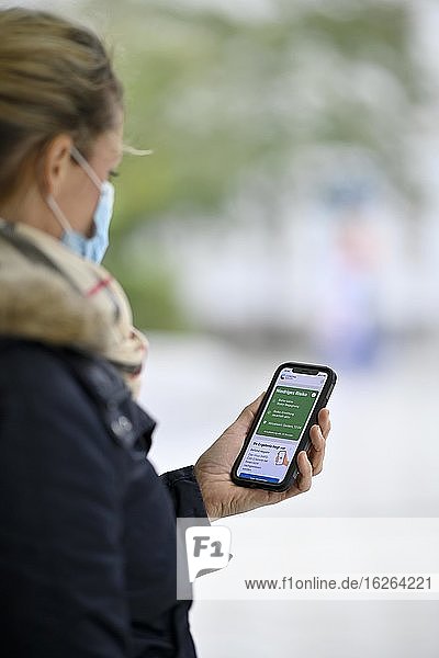 Negative test result  woman with face mask  showing smartphone with Corona Warn-APP  Corona crisis  Stuttgart  Baden-Württemberg  Germany  Europe