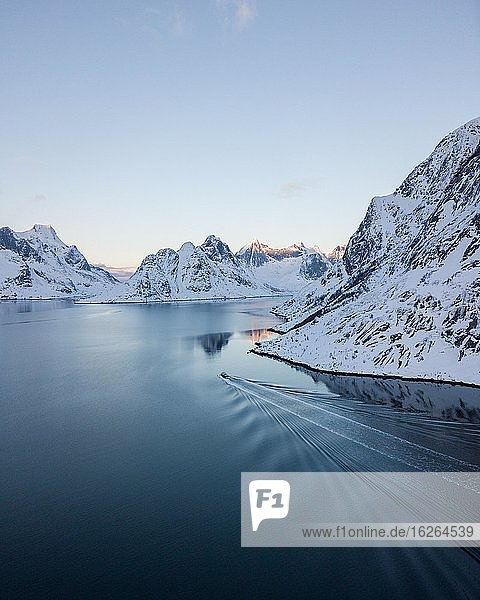 Luftaufnahme  Reinefjord mit verschneiten Bergen im Winter mit einem Fischkutter  Norwegen  Europa