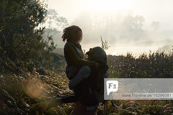 Silhouette liebevolles junges Paar beim Wandern in der Natur