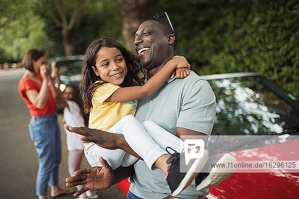 Glücklicher Vater hält Tochter außerhalb des Cabriolets