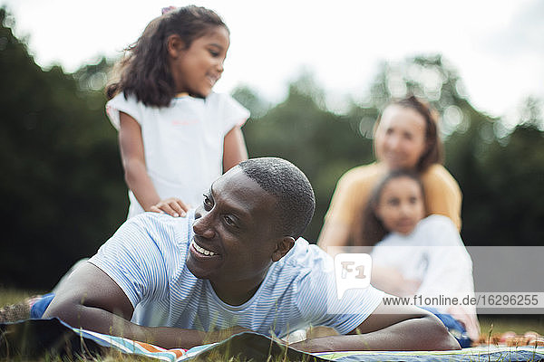 Glücklicher Mann genießt Picknick im Park mit der Familie