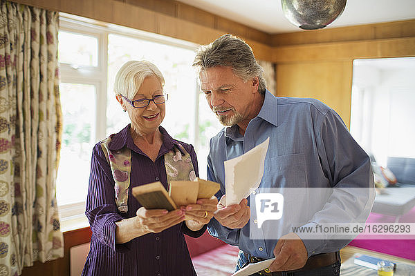 Älteres Ehepaar betrachtet Holz- und Farbmuster im Wohnzimmer