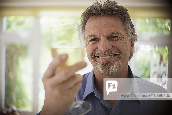 Close up portrait happy carefree senior man drinking white wine