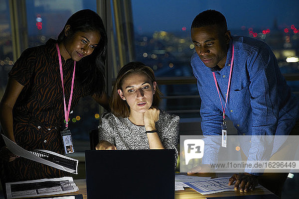 Geschäftsleute die spät am Laptop im Büro arbeiten