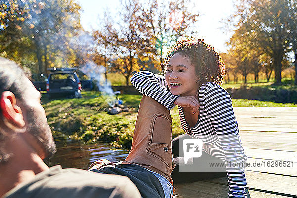 Glückliches junges Paar entspannt auf sonniger Herbstanlegestelle