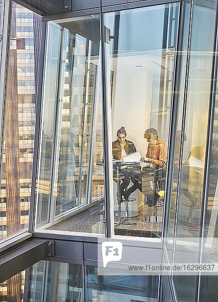 Geschäftsleute treffen sich am Fenster eines modernen Hochhausbüros