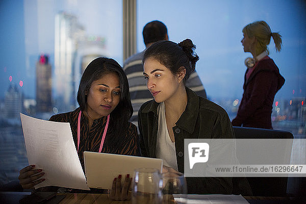 Geschäftsfrauen mit digitalem Tablet arbeiten spät im Büro