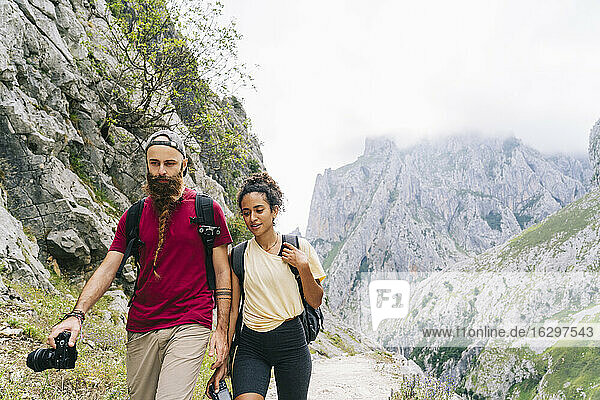 Wanderer mit Kamera in der Hand beim Wandern auf einem Bergpfad an der Ruta Del Cares  Asturien  Spanien