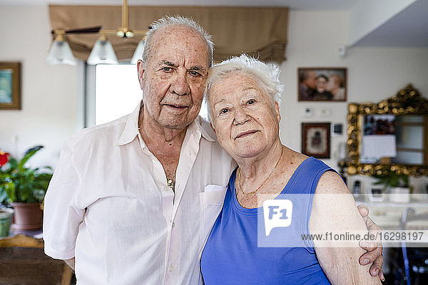Senior couple looking at camera at home