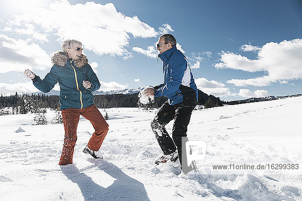 Germany  Bavaria  Winklmoosalm  Mature couple having a snowball fight
