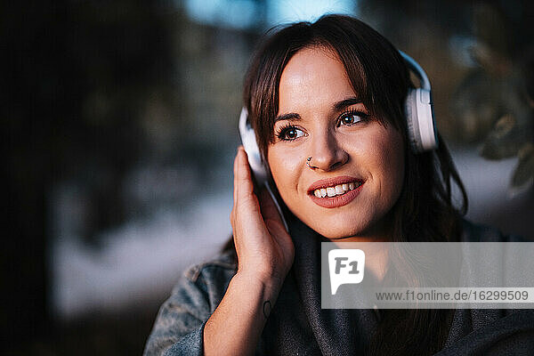 Attractive woman listening to music through headphone in forest