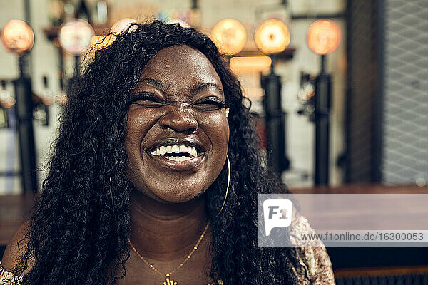 Porträt einer lachenden Frau in einer Kneipe