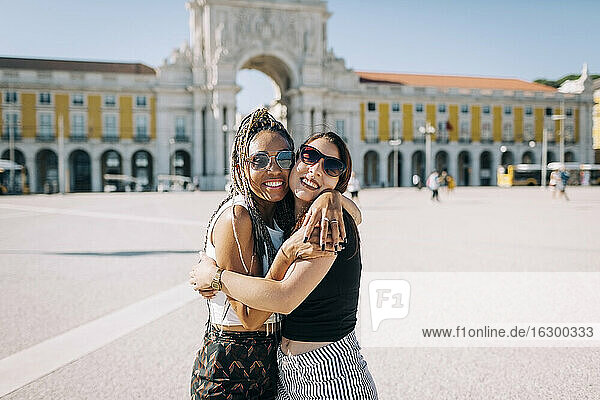 Happy women embracing each other at Praca Do Comercio  Lisbon  Portugal