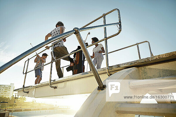 Freunde spielen Urban Golf auf dem Highboard eines Swimmingpools