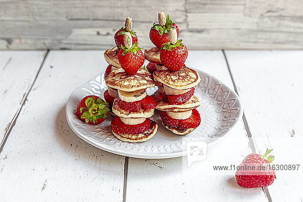 Teller mit Mini-Pfannkuchen mit Erdbeeren und Bananen