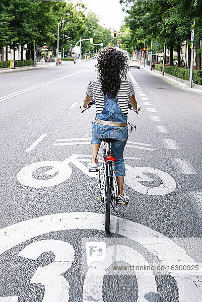 Frau fährt Elektrofahrrad auf der Straße in der Stadt