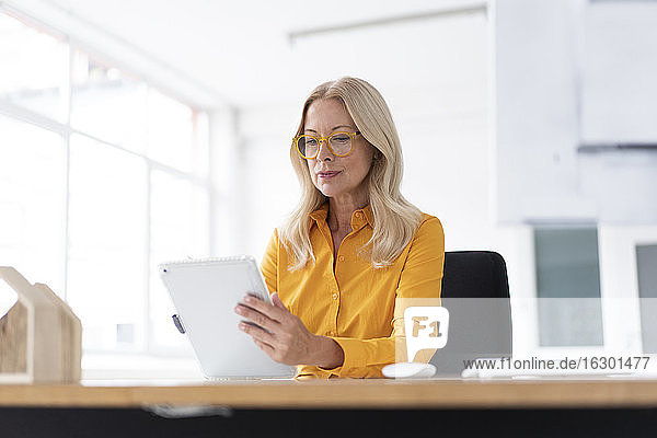 Geschäftsfrau verwendet digitales Tablet auf dem Schreibtisch bei der Arbeit im Home Office