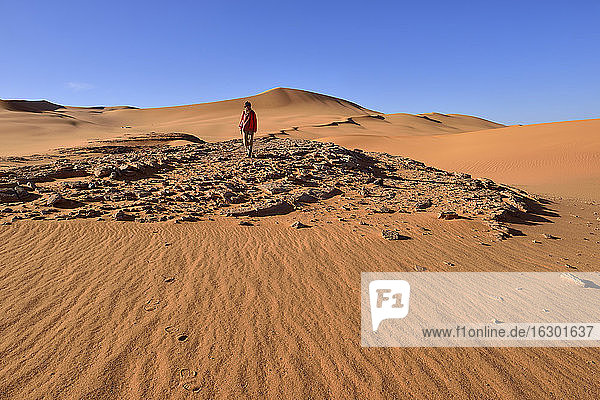 Algeria  Sahara  Tassili N'Ajjer National Park  Woman walking in the dunes of In Tehak