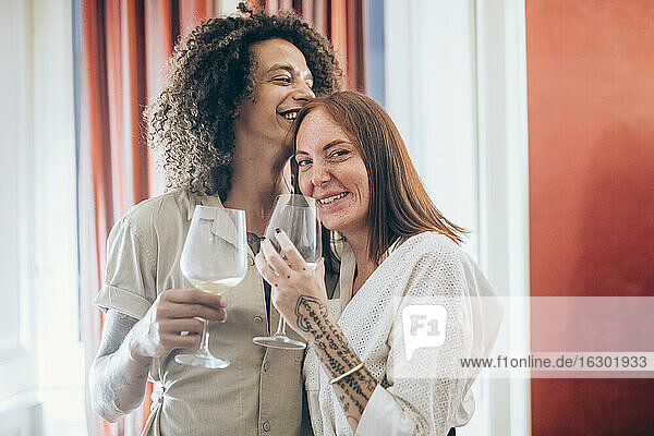 Happy couple having wine during party at home