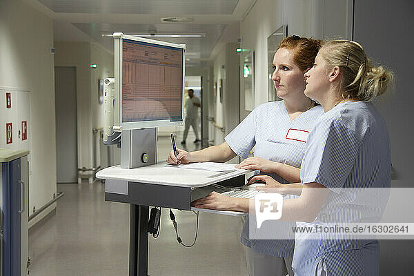 Deutschland  Freiburg  Krankenschwestern und -pfleger mit mobilen Computern bei der Überprüfung von Patientendaten