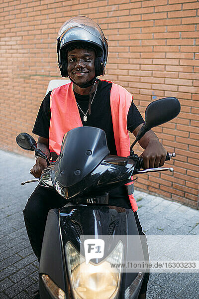 Happy delivery man on motorbike