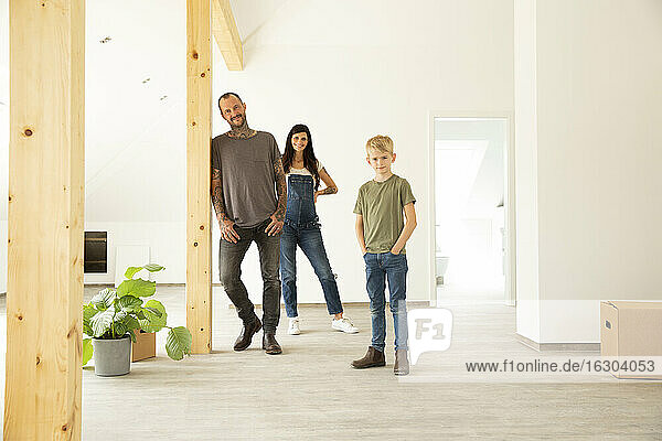 Familie steht auf dem Hartholzboden im Dachgeschoss des neuen Hauses
