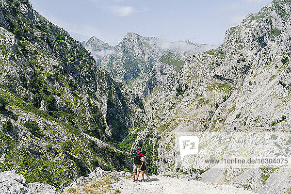 Paar betrachtet die Aussicht  während es auf einem Berg an der Ruta Del Cares steht  Asturien  Spanien