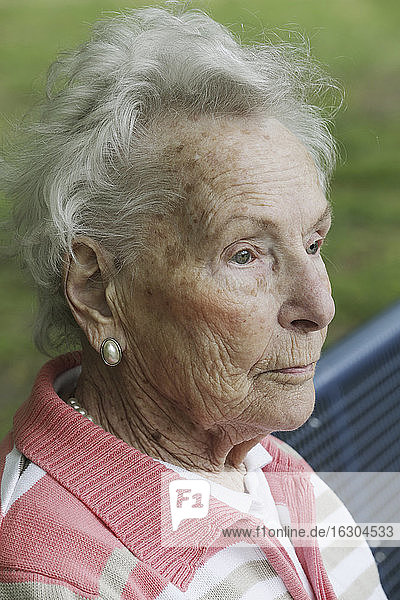 Deutschland  Nordrhein-Westfalen  Köln  Ältere Frau sitzt auf Bank