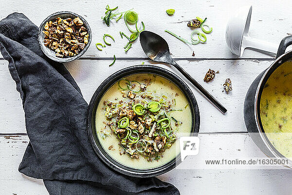 Schüssel vegetarische Lauchsuppe mit Käse und gerösteten Walnüssen