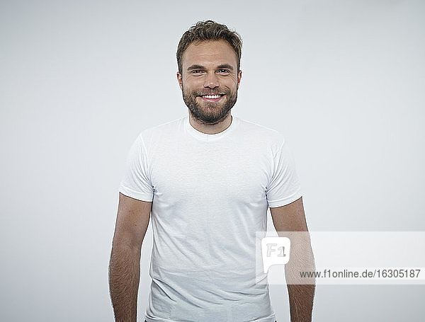 Portrait of smiling man in front of white background