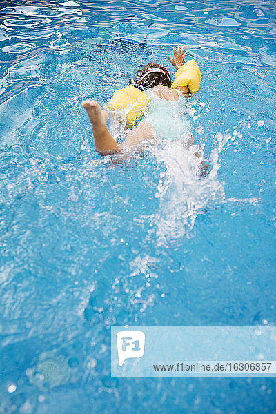 Kleines Mädchen taucht im Schwimmbad