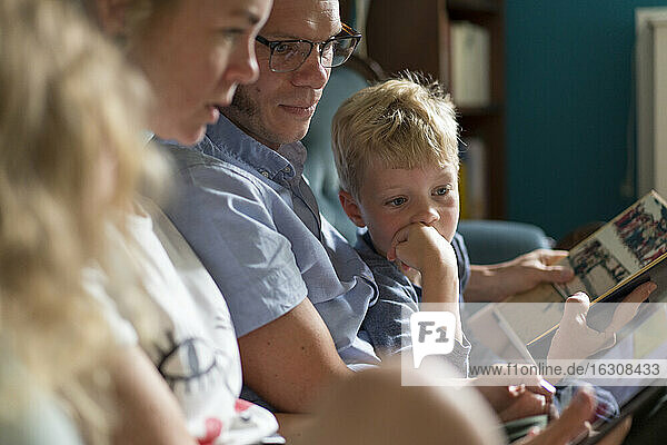 Familie mit digitalem Tablet im heimischen Wohnzimmer sitzend