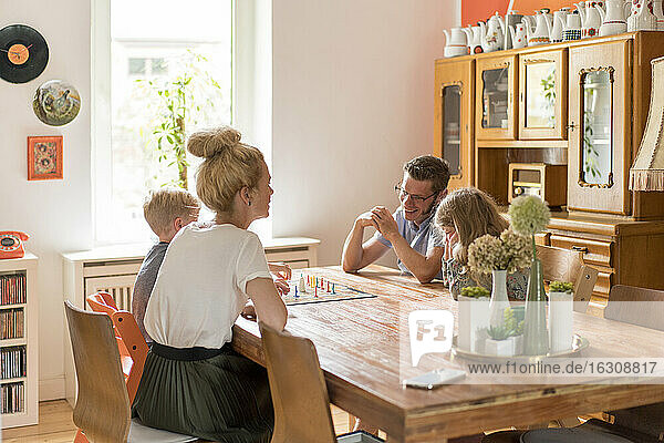 Glückliche Familie spielt Brettspiel am Esstisch zu Hause