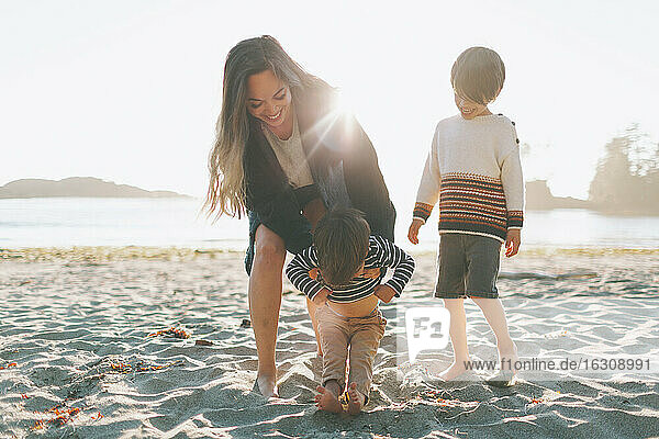 Woman playing with children at beach