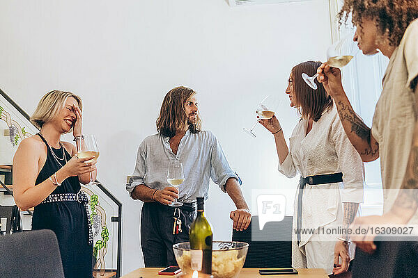 Young friends enjoying wine during party at home