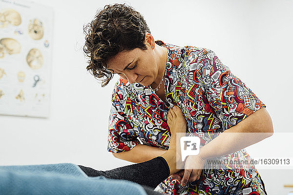 Sportlerin erhält Fußmassage vom Osteopathen im Heilbad