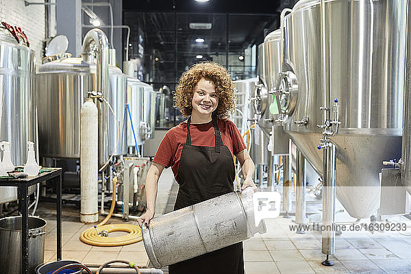 Portrait of smiling woman working in craft brewery