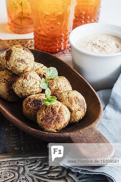 Fried oat balls with tomato sauce and bowl of dipping sauce