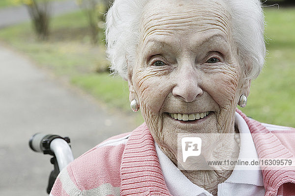 Deutschland  Nordrhein-Westfalen  Köln  Porträt einer älteren Frau im Rollstuhl sitzend  lächelnd