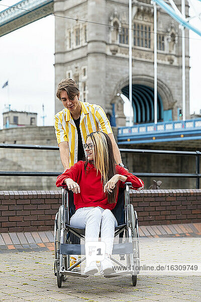 Young man spending leisure time with disabled female friend during weekend  London  UK