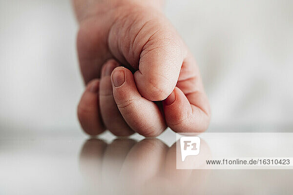 Close-up of newborn baby girl hand on table in hospital