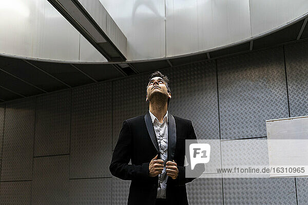 Thoughtful male professional wearing suit looking through skylight at station
