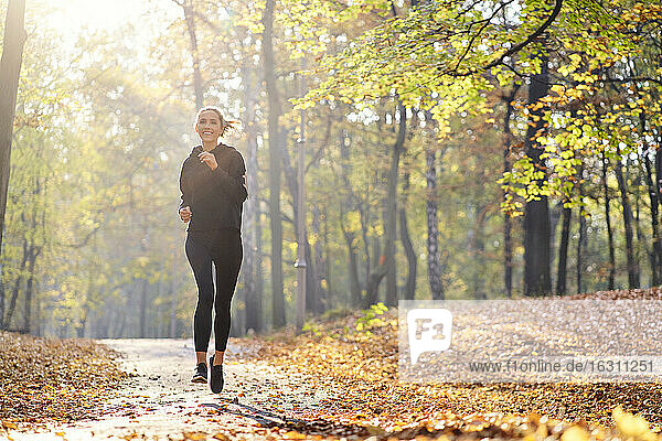 Junge Frau joggt im Herbstwald