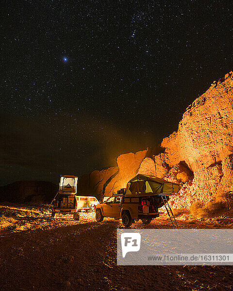Geländewagen in beleuchtetem Wüstencamp bei Nacht