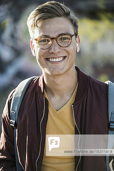 Lächelnder gut aussehender junger Mann mit Brille