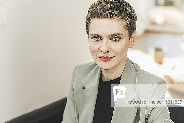 Close-up of confident businesswoman with short hair sitting at home
