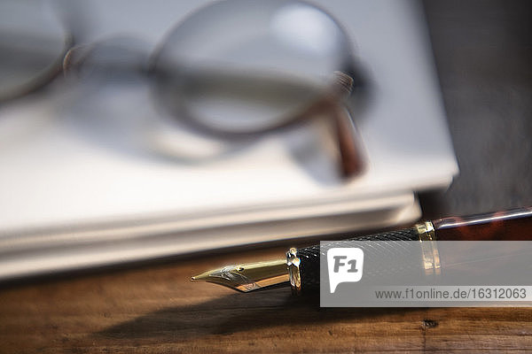 Retro-Brille und Stift auf Papierstapel