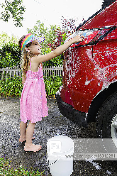 Mädchen (6-7) beim Autowaschen im Hinterhof